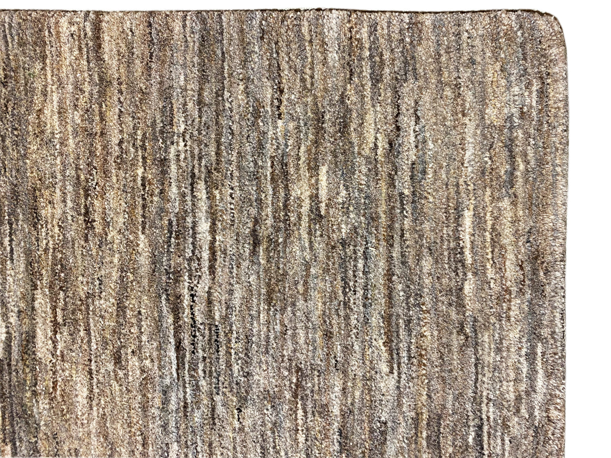 Close-up: 243x168 rug with a dense, mottled gray-brown texture at the edge.