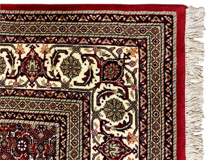 Bidjar rug edge view with fringe, red pattern, and cream-black decorative border