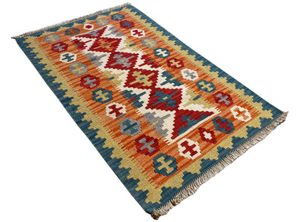 Diagonal kilim rug, geometric pattern in blue, orange, and cream, fringes
