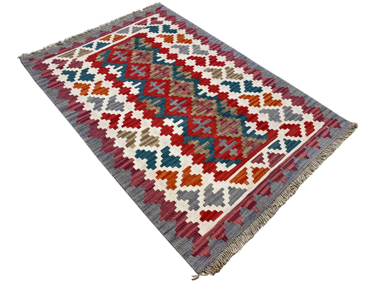 Multicolored kilim rug with a geometric cross pattern and fringes along the edge