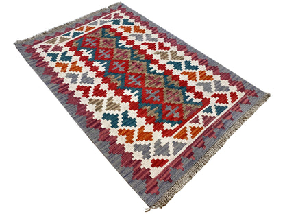 Multicolored kilim rug with a geometric cross pattern and fringes along the edge