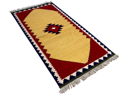 Angled kilim rug: yellow diamond motif with red and blue decorative stripes