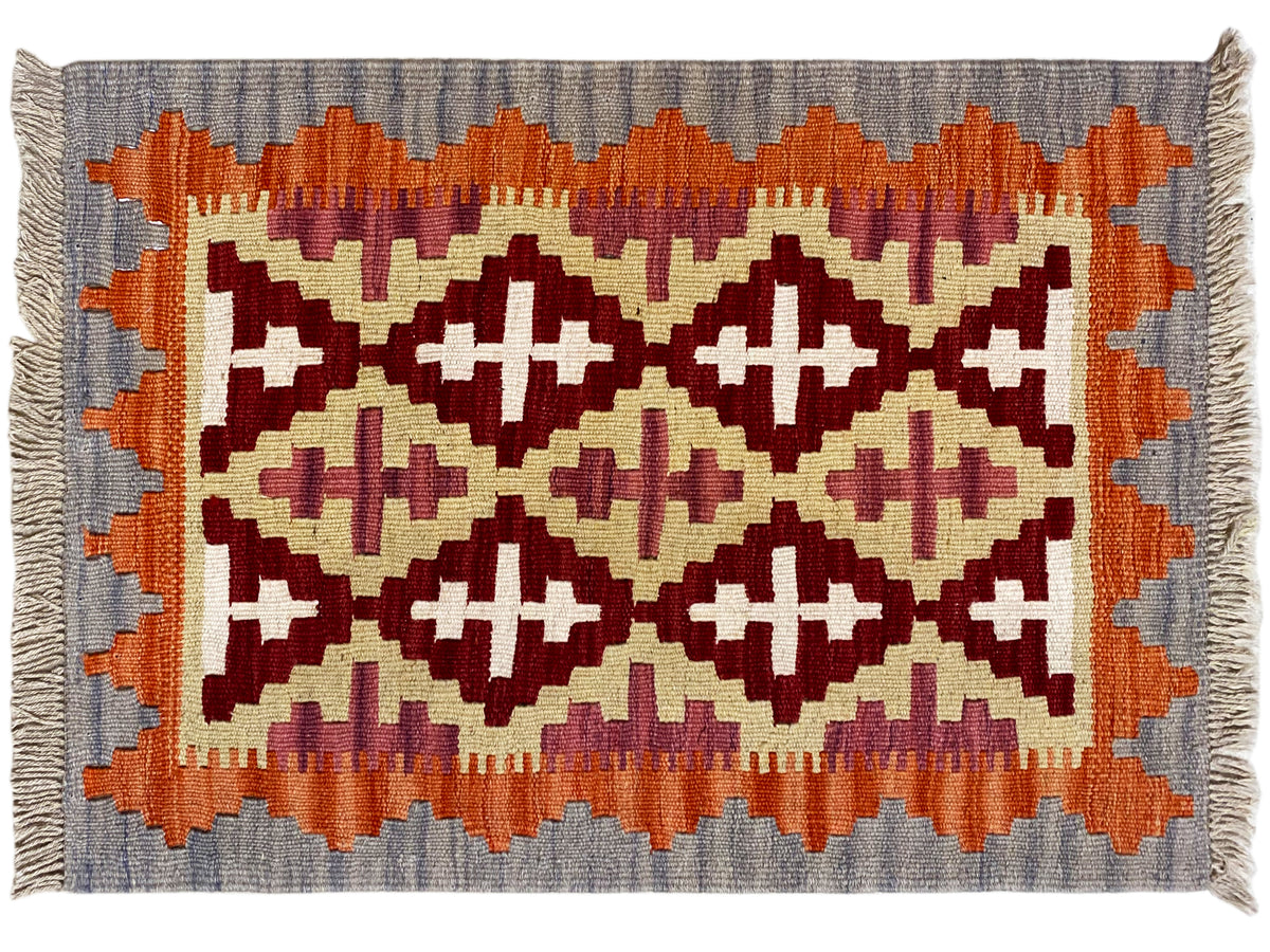 Kilim rug with a wide border and zigzag patterns in orange, cream and dark red