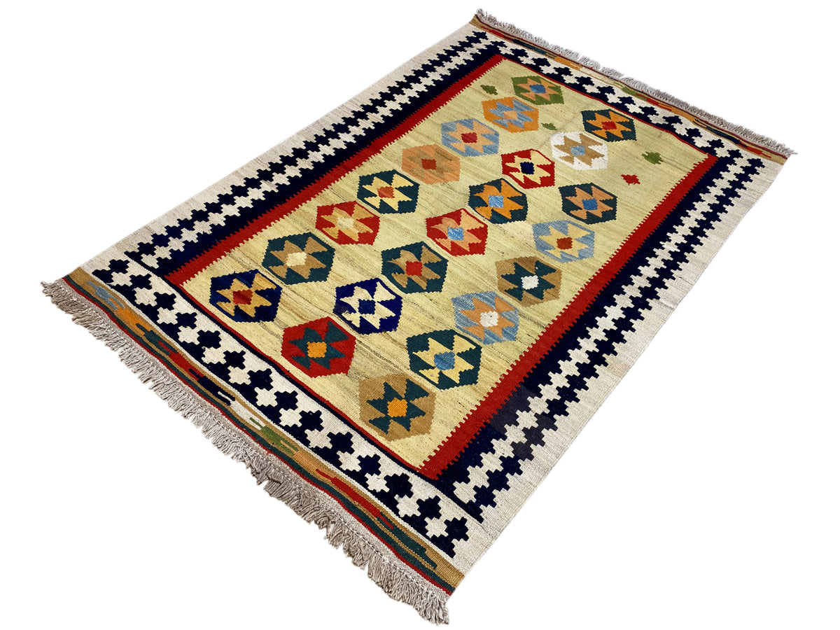 Beige Kelim Qashqai rug with a colorful geometric field, decorative border, and fringe