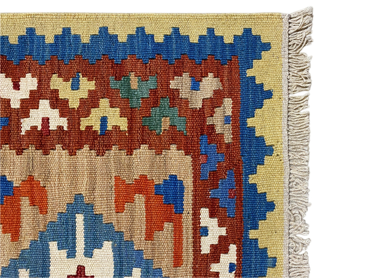 Border area of a kilim rug with fringes and blue edging, multicolored ornaments