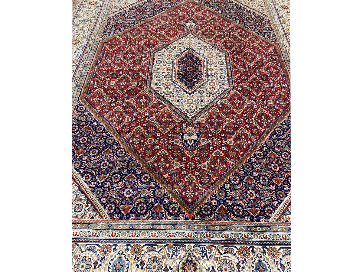 Close-up: red medallion in dark blue with white patterned corners and border at the bottom
