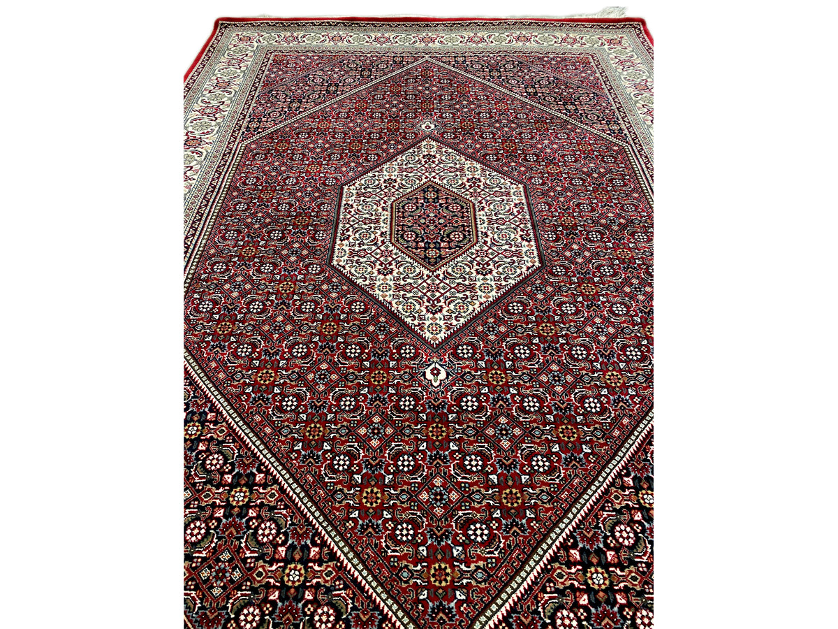 Red carpet with diamond medallion and intricate ornamentation in cream and dark blue