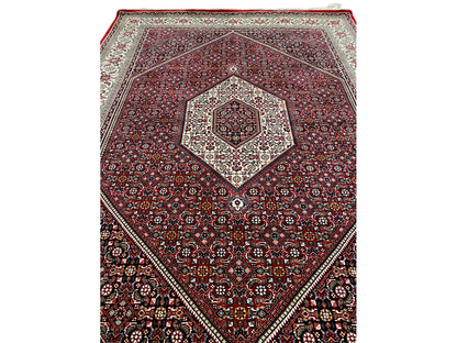 Red carpet with diamond medallion and intricate ornamentation in cream and dark blue