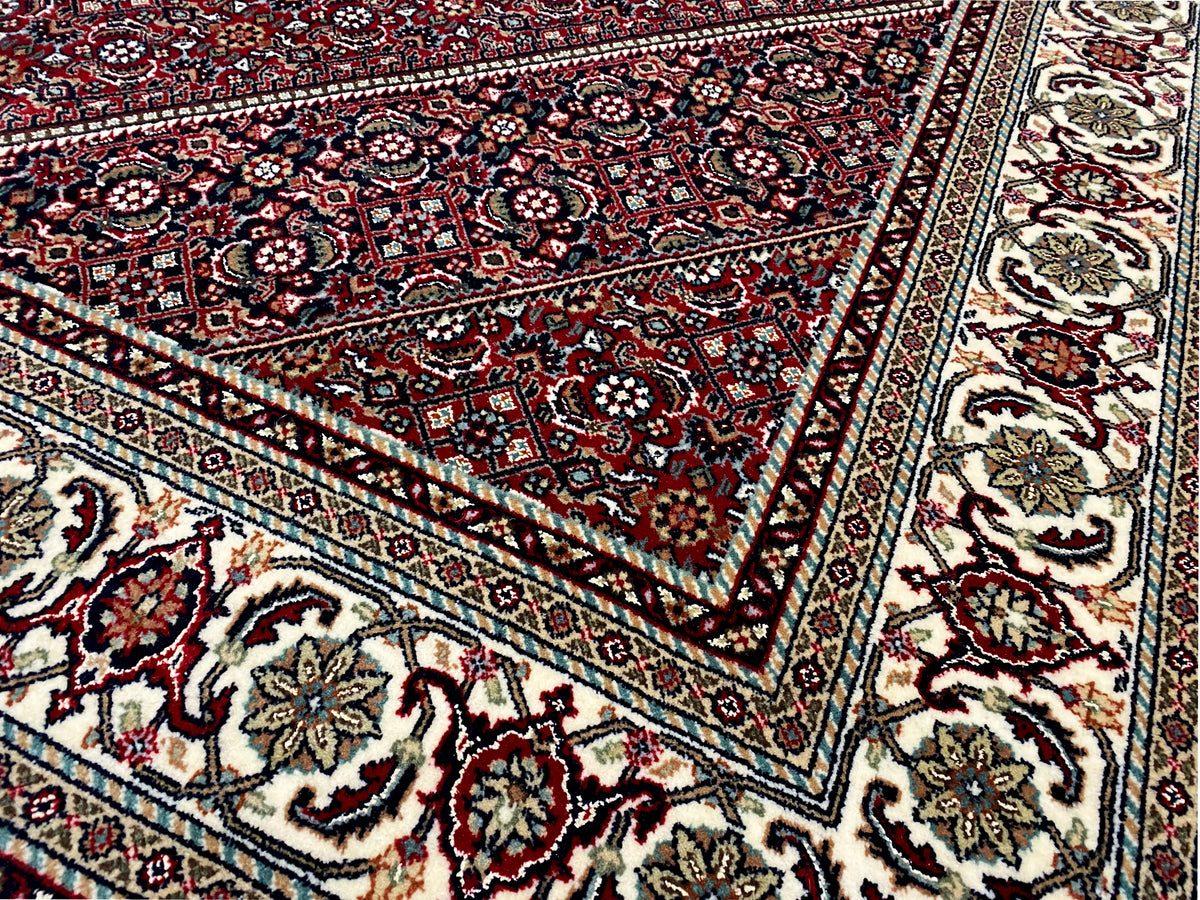 Close-up of a rug: red ornamental field with fine lines and borders