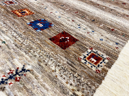 Gabbeh runner rug close-up: bordered motifs in blue, red, and brown