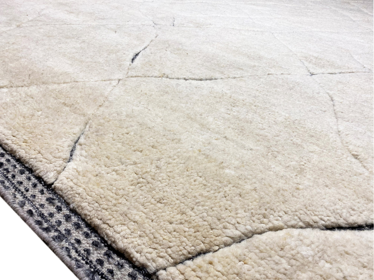 Berber rug, cream-colored pile with a dark blue border and linear pattern