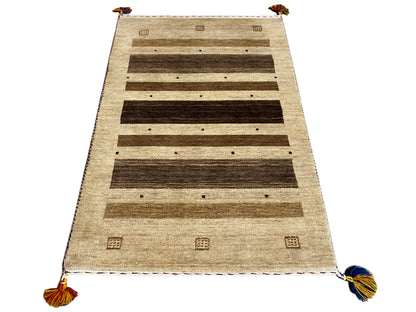 Gabbeh runner rug with a beige background, rows of dark stripes, and colorful tassels