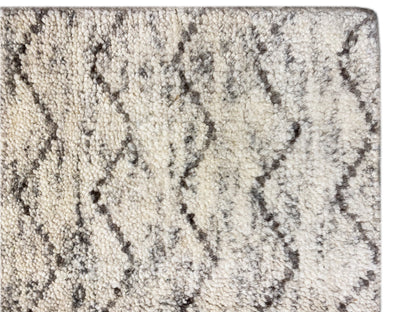 Berber rug close-up: light pile with a gray zigzag pattern and knotted texture