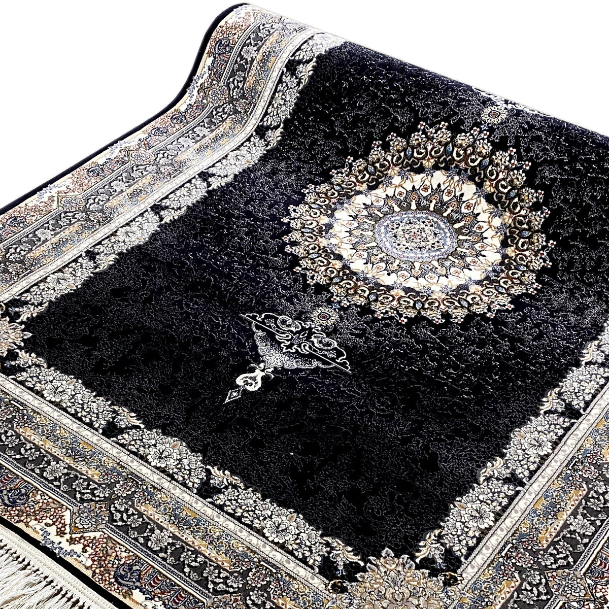 Side view of a black rug: woven decorative border, central medallion, fringe