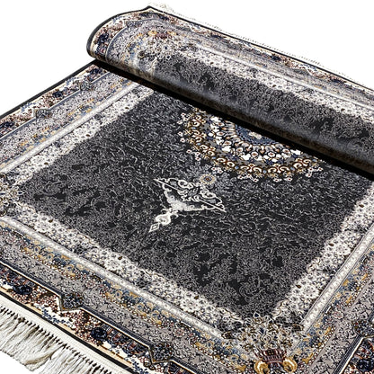 Black oriental rug rolled up, with silver lines, a golden medallion, and decorative borders