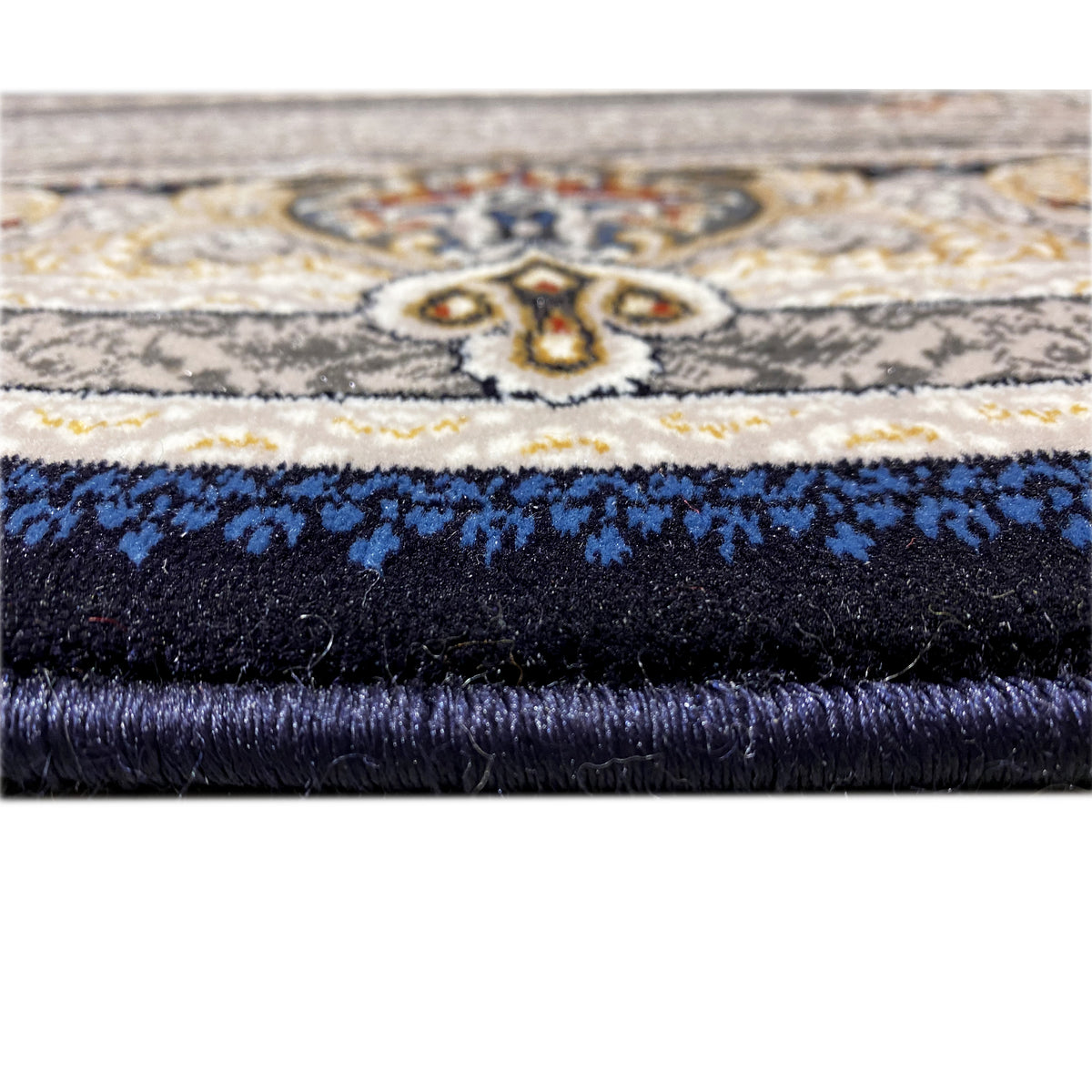 Carpet edge in detail: fringe at the top, dark pile, and blue ornamental band