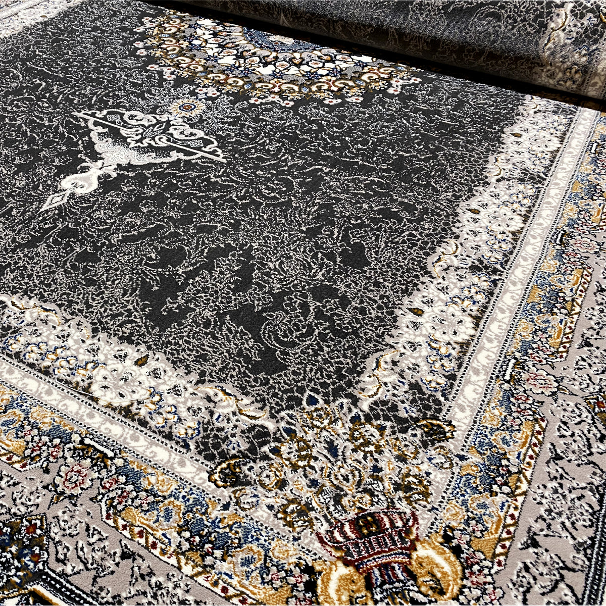 Oriental rug in dark gray/black with a light ornamental medallion and decorative borders