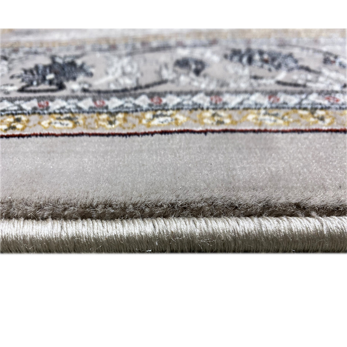 Close-up of the carpet edge with fringe and fine fibers, gray mottled fabric