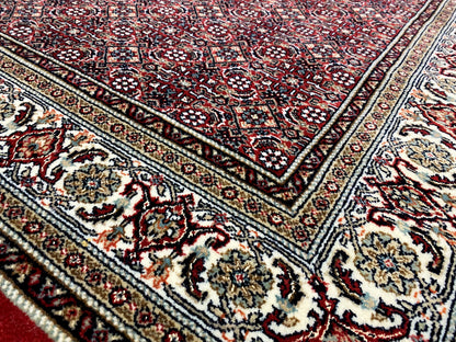 Bidjar rug corner detail: ornamental border, dark red, cream, and black