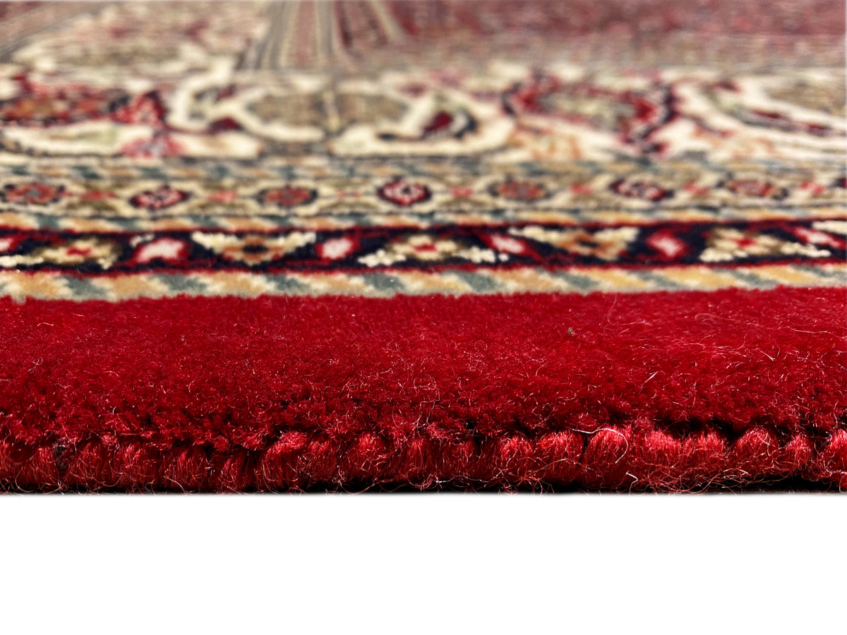 Close-up of the carpet edge with red pile and a patterned border