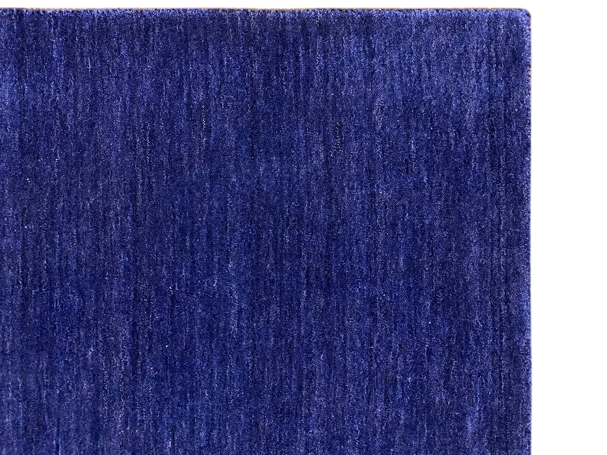 Blue carpet close-up: dense low-pile surface with a fine, irregular grain.