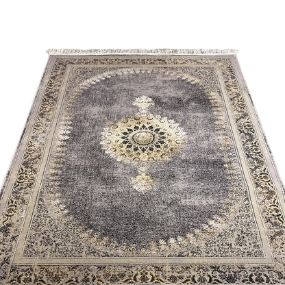 Close-up of a medallion rug: dark gray with a gold-colored center and decorative border
