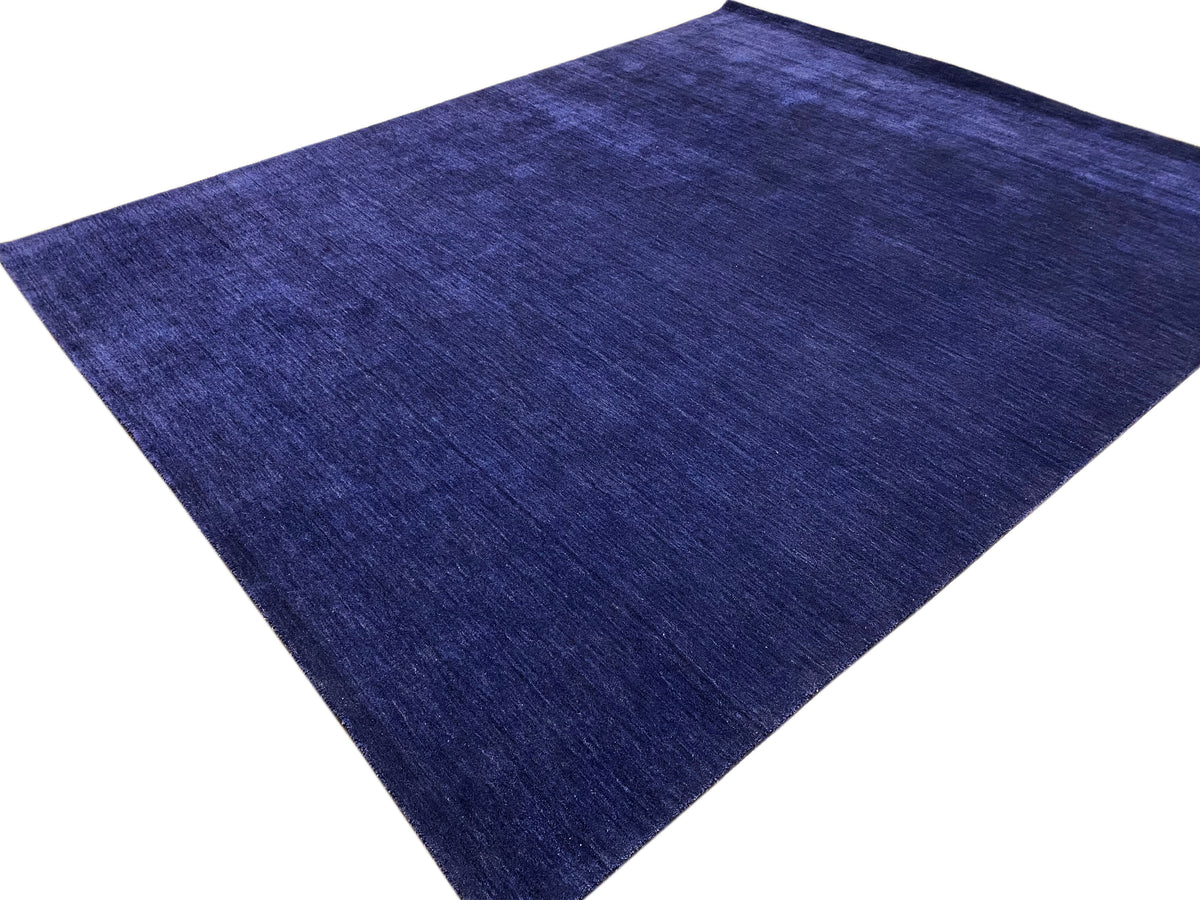 Blue carpet viewed at an angle with a fine, even pile texture.