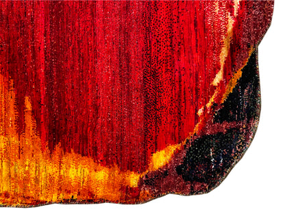 Close-up of a carpet: dense, glossy red pattern with an orange-yellow border and dark dots