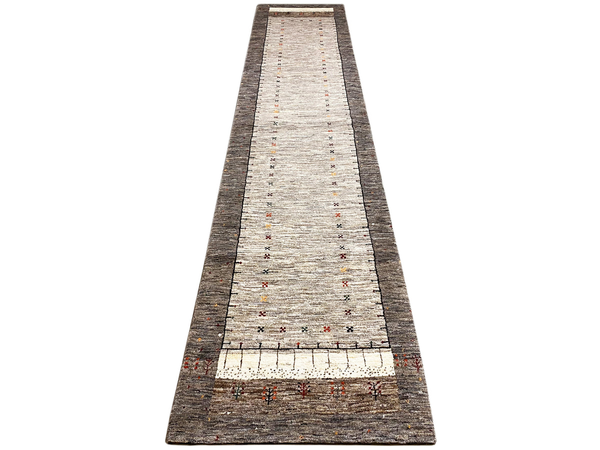 Gabbeh runner rug, straight-on front view, light central area with fine colorful decorations