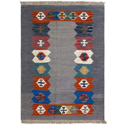 Gray speckled kilim rug with a medium border of colorful symbols and fringes