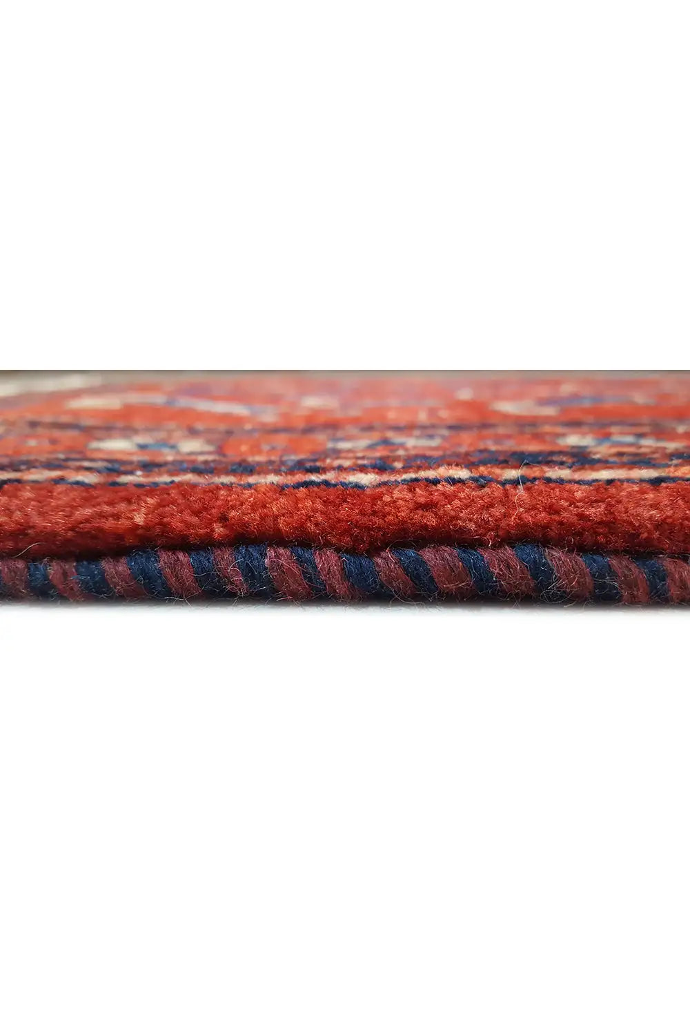 Carpet edge with red pile and blue pattern, visible selvedge