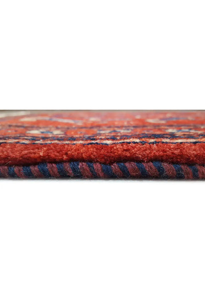 Carpet edge with red pile and blue pattern, visible selvedge