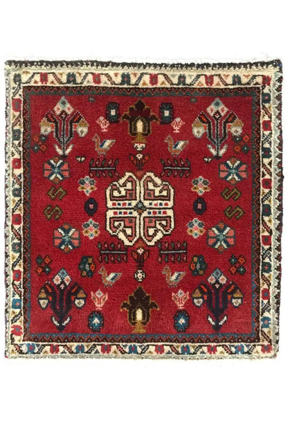 Square red Oriental rug with medallion, decorative border and fringes
