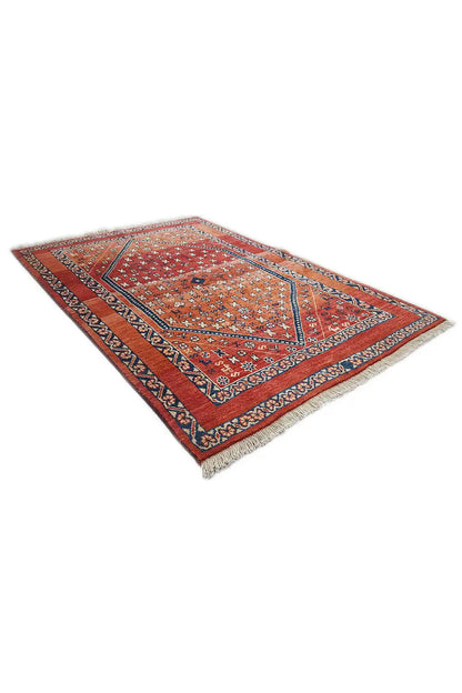 Rolled-up Oriental rug, red pile, blue-and-white-trimmed border, decorative motifs