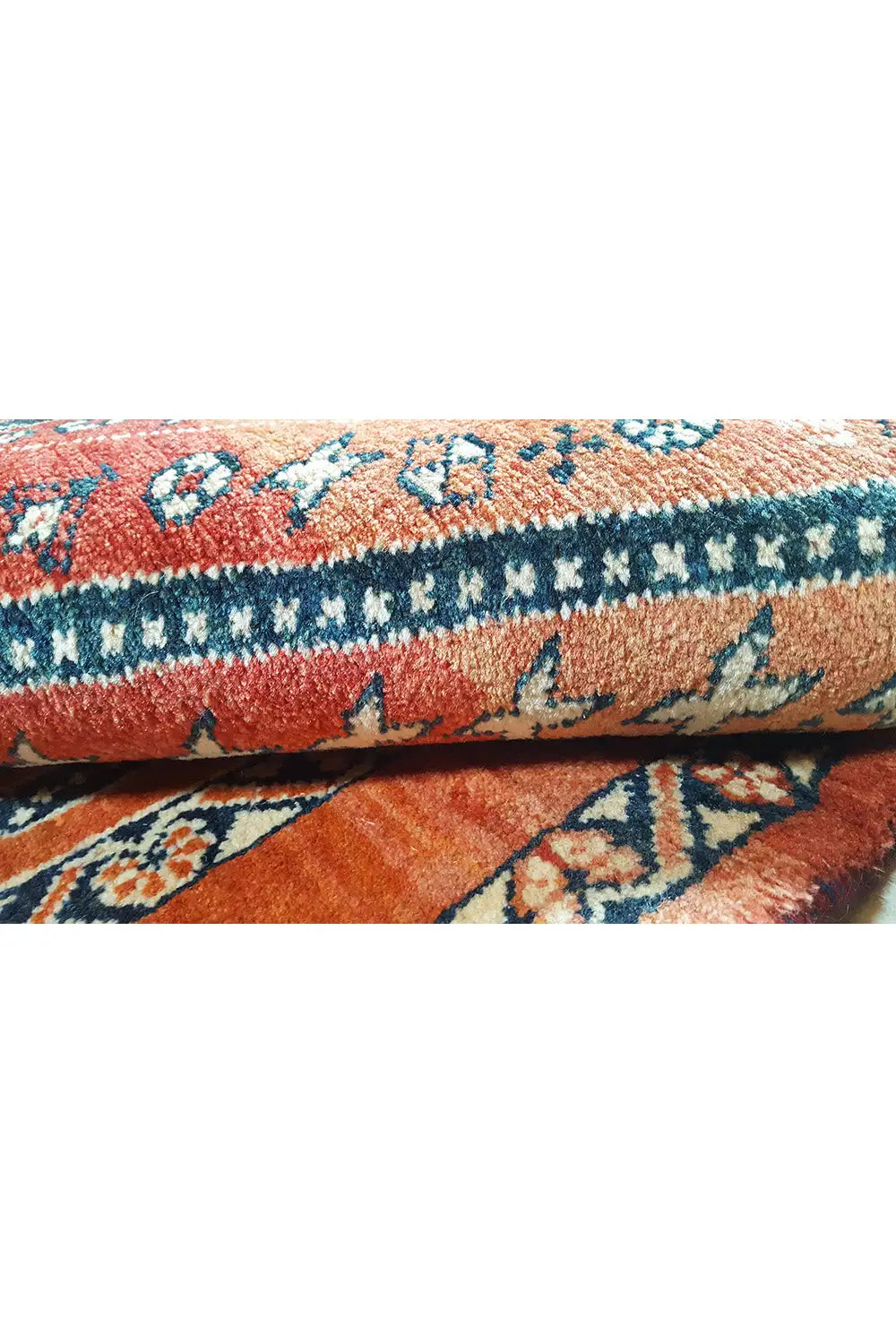 Carpet detail: fringe and edge stitching, red background with blue ornamental motifs