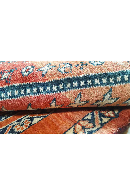 Carpet detail: fringe and edge stitching, red background with blue ornamental motifs