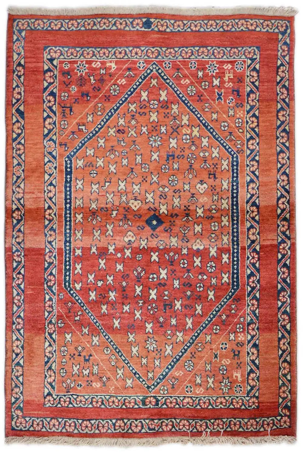 Oriental rug with a red ground, blue border, and geometric medallion pattern