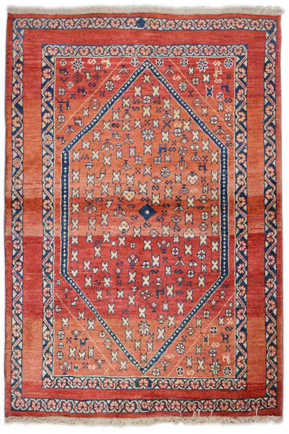 Oriental rug with a red ground, blue border, and geometric medallion pattern