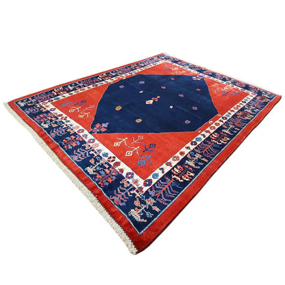 Rectangular rug with a red outer field, blue center, and ornamental border