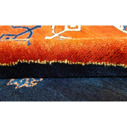 Close-up of carpet edge: red-orange pile with a dark border and fringes