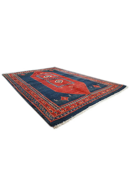 Rectangular rug with a blue background, red patterned area, and colorful fringed edge