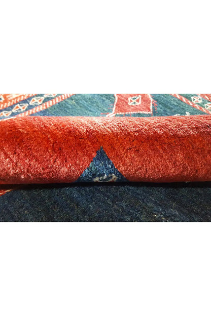 Close-up: carpet pile with a red edge and blue design in the seam area