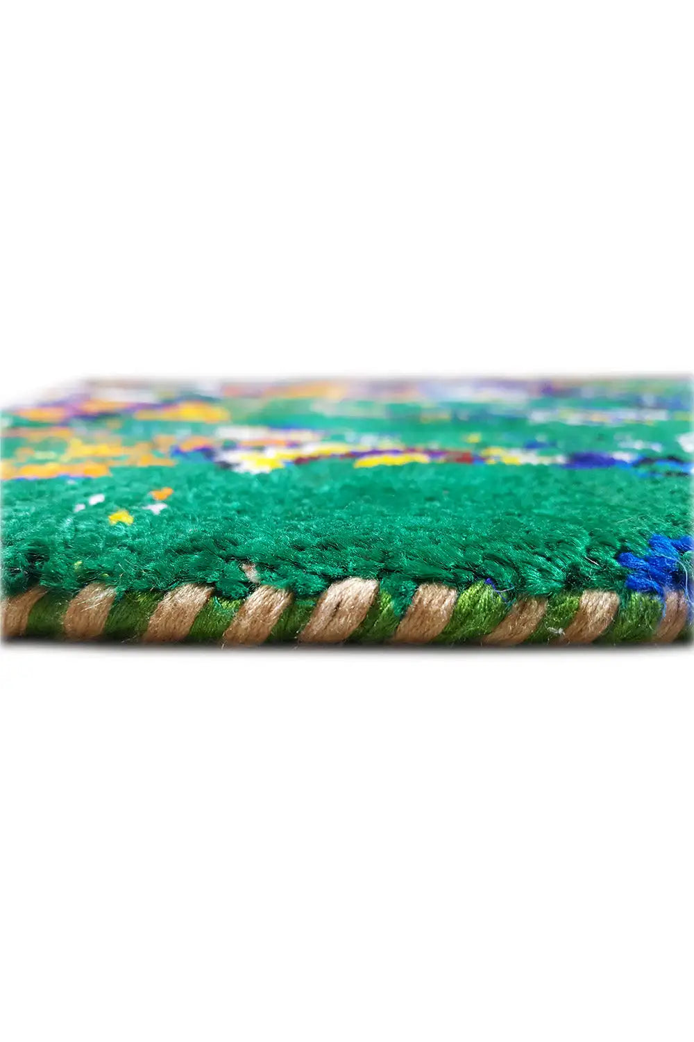 Close-up of a sari silk rug: fringes at the bottom and green patterned area