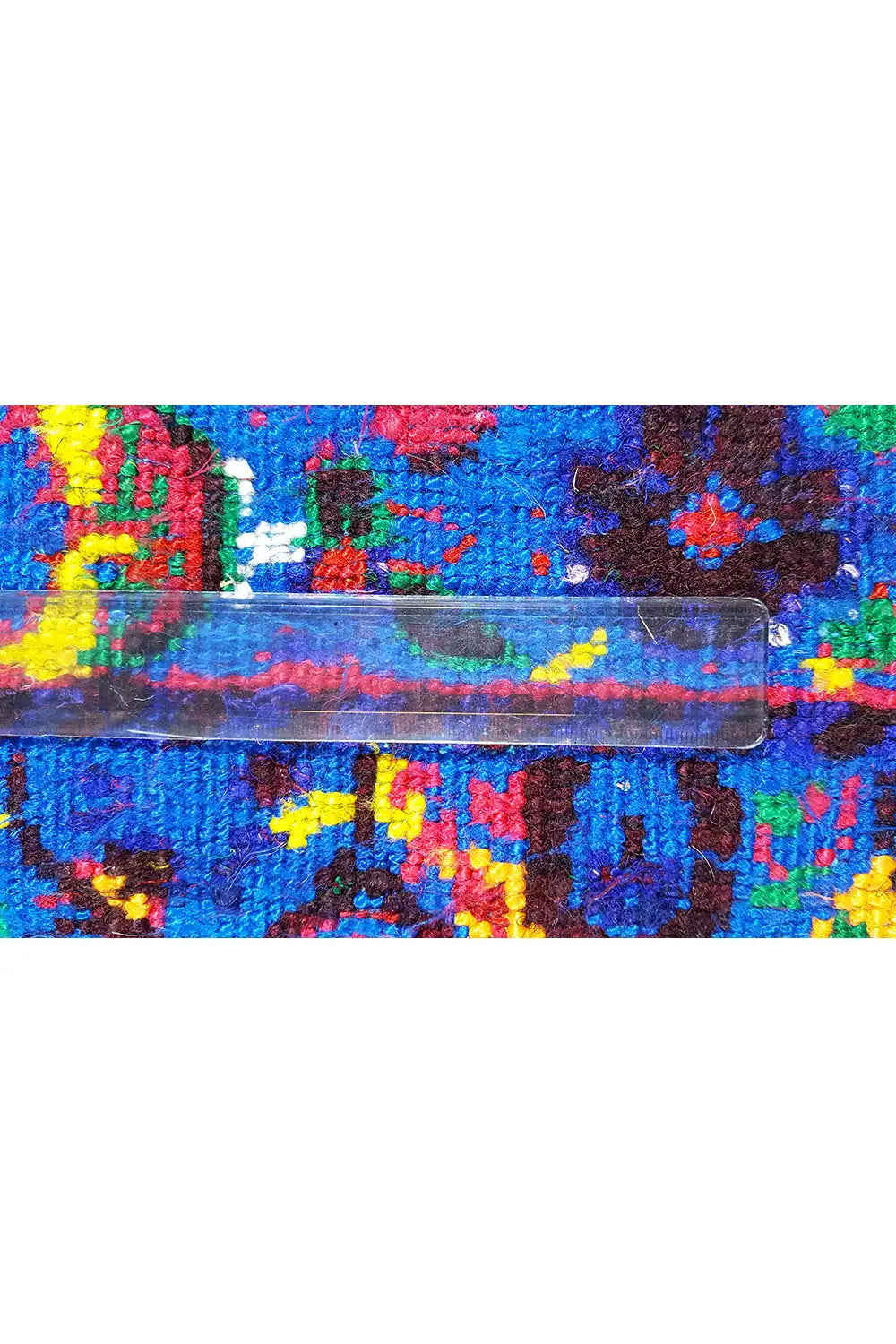 Close-up: Edge detail of a blue silk scarf with colorful ornaments