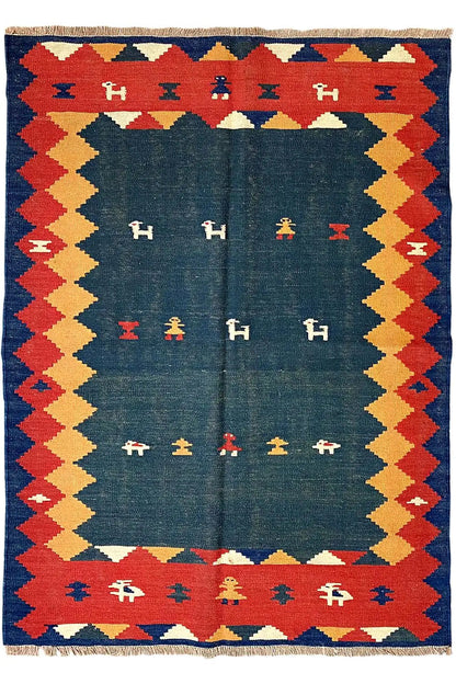 Kilim rug with a blue central section, diamond border in red, blue and yellow, and fringes
