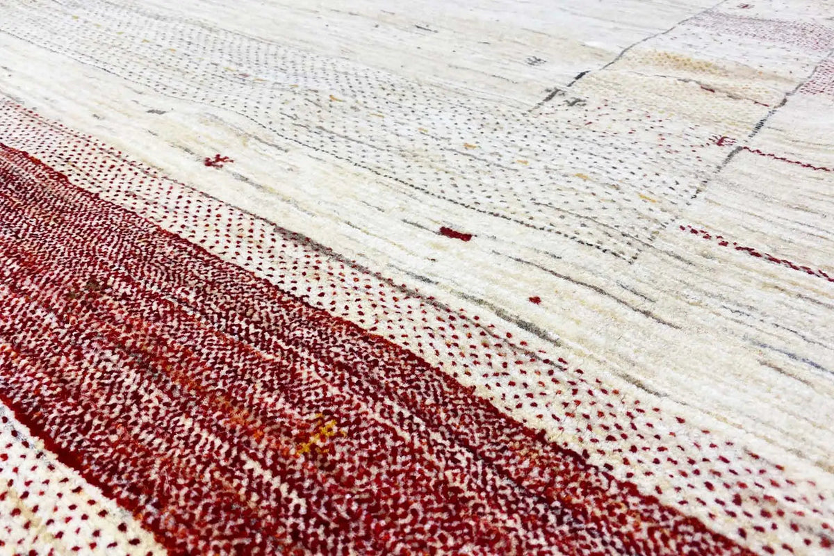 Gabbeh rug close-up: beige textured weave with a dark red horizontal stripe