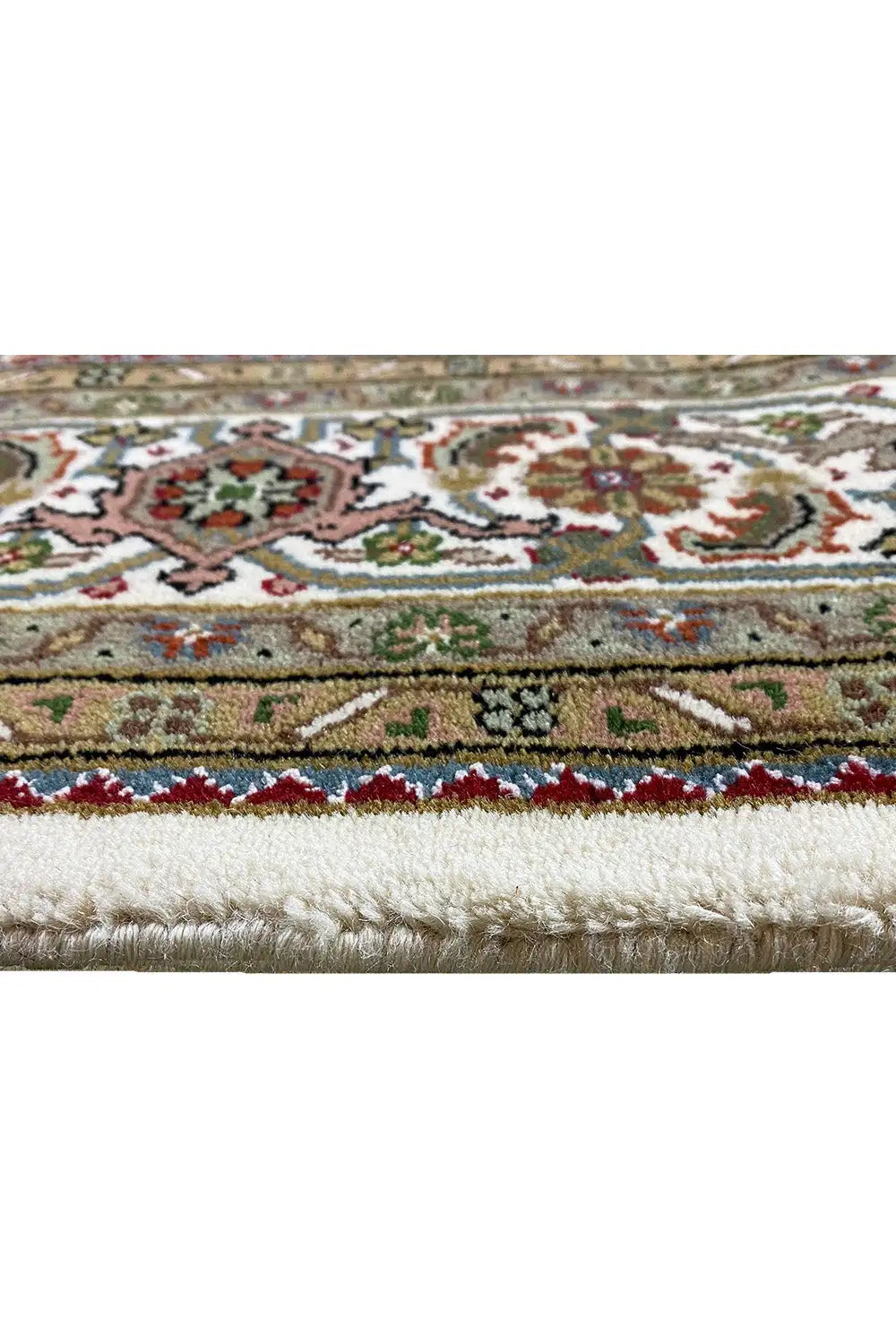 Indo Tabriz rug: close-up of the border in beige, green, and red with fringes