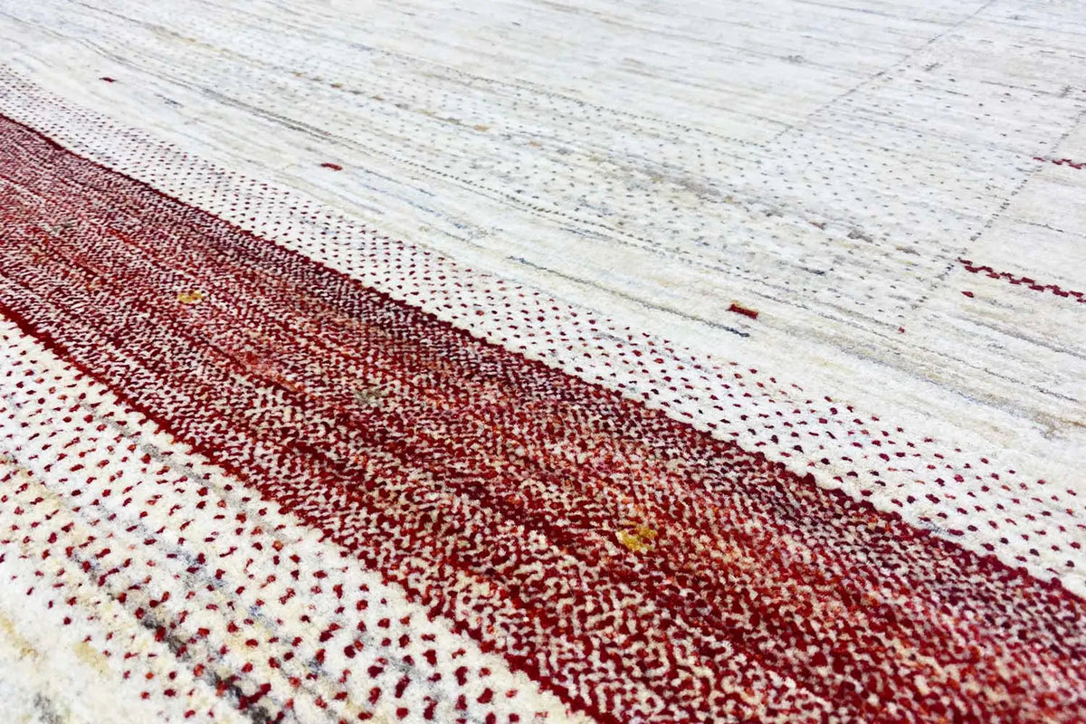 Close-up: Gabbeh rug with a reddish stripe and dots on a beige background