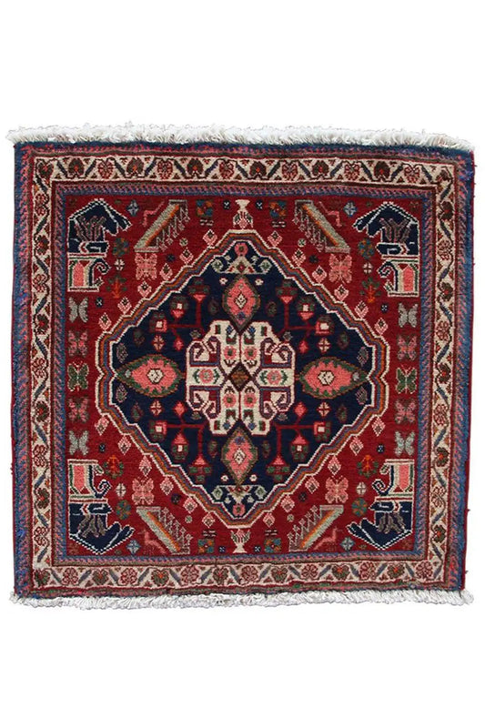 Oriental rug with a red background, dark center, and ornamental border, fringes