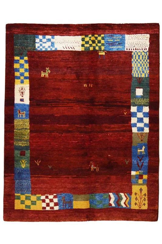 Gabbeh rug with a red central section and multicolored border of geometric bands